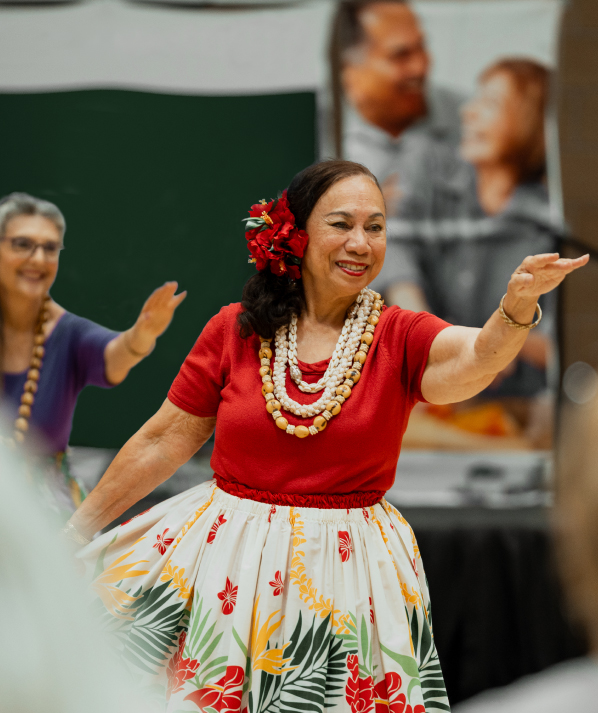 A senior woman in bright clothing dances
