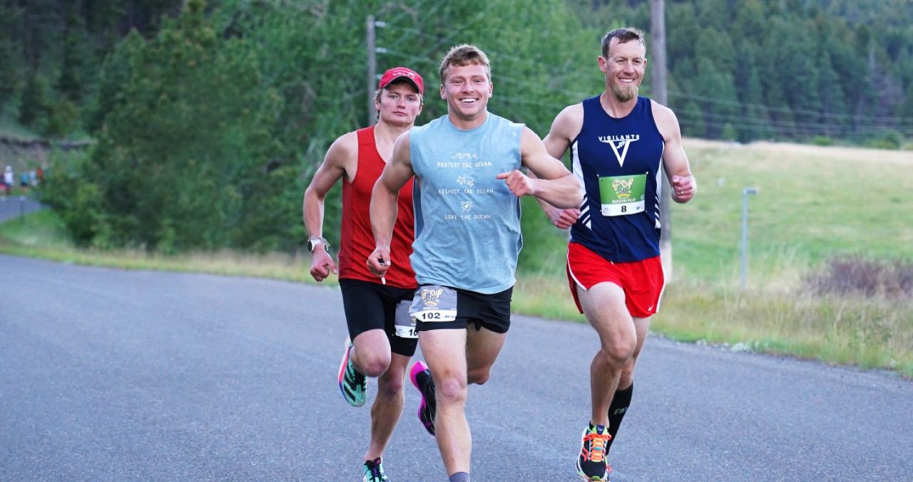 Three men running Governor's Cup race on open road