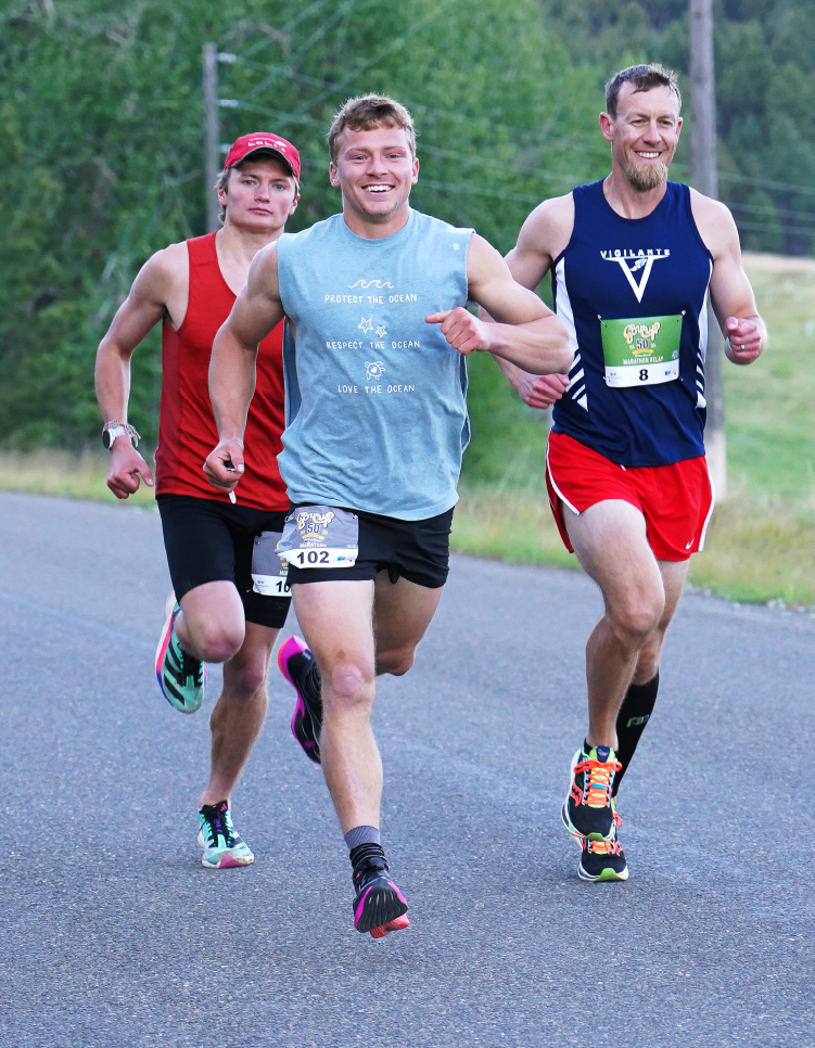 Three men running Governor's Cup race on open road