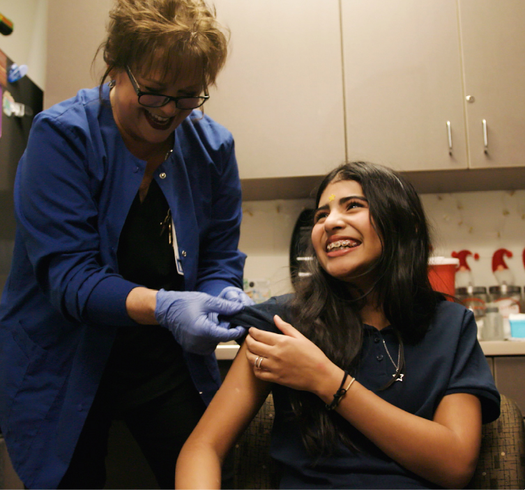 Teen girl gets vaccination from nurse
