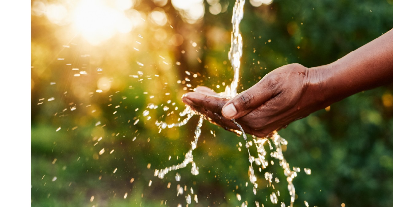 Water pouring into cupped hands, splashing out