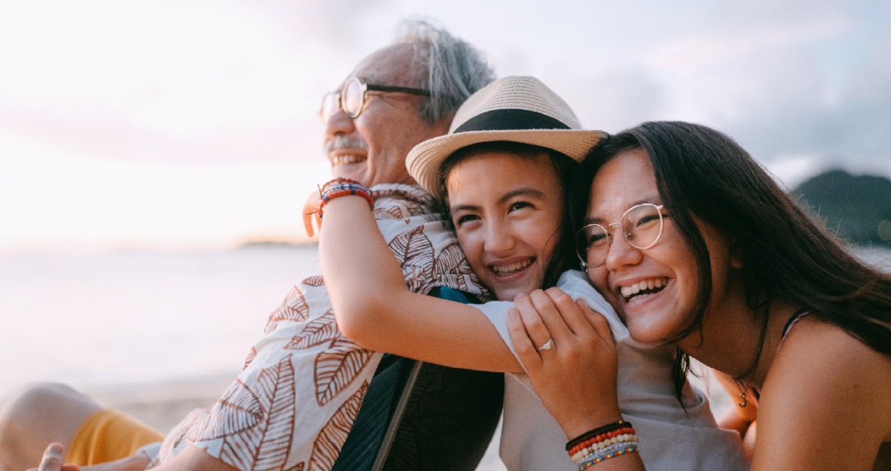 Multigenerational family hugging at beach