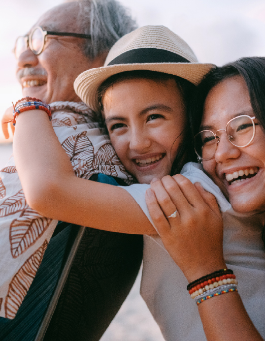 Multigenerational family hugging at beach