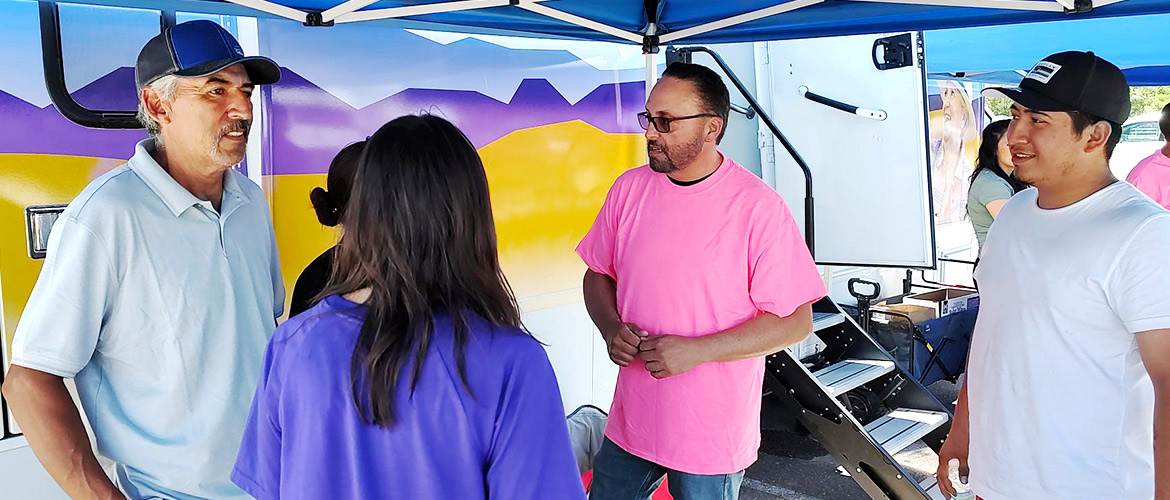 People speak to each other under a canopy