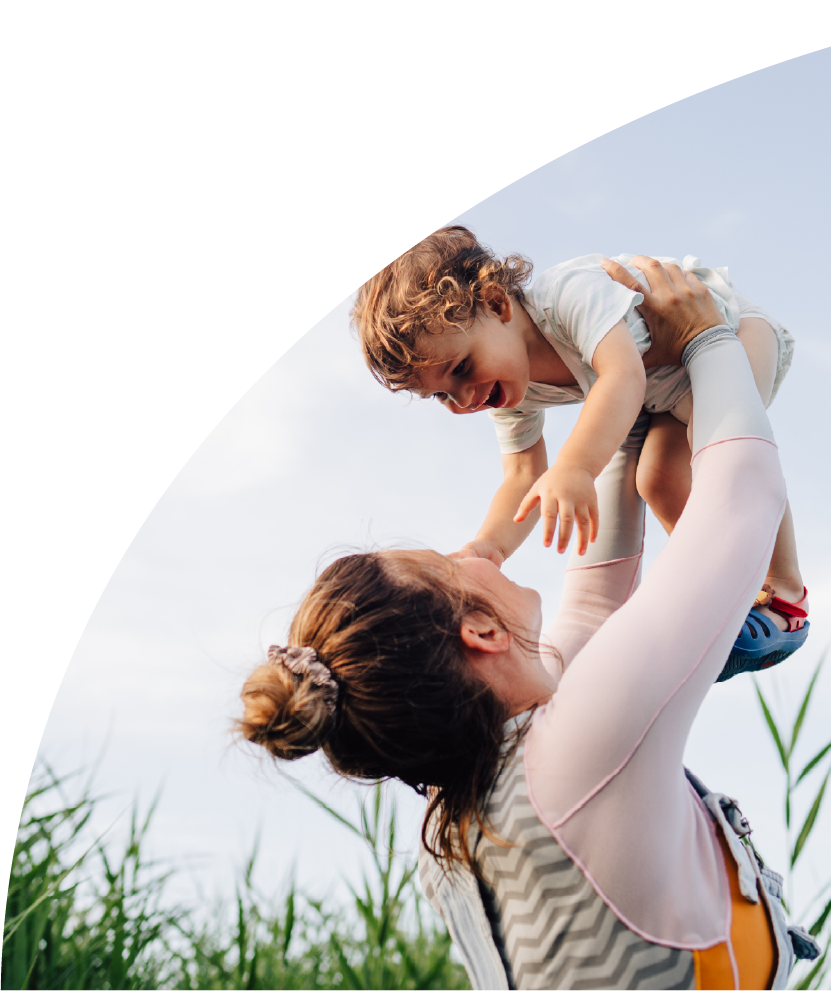 Spring day of a mother lifting child.
